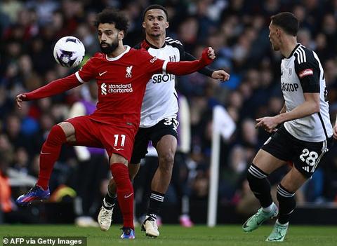 Liverpool s Egyptian striker #11 Mohamed Salah (L) vies with Fulham s English-born US defender #33 Antonee Robinson (C) and Fulham s Serbian midfielder #28 Sasa Lukic during the English Premier League football match between Fulham and Liverpool at Craven Cottage in London on April 21, 2024. (Photo by BENJAMIN CREMEL / AFP) / RESTRICTED TO EDITORIAL USE. No use with unauthorized audio, video, data, fixture lists, club/league logos or live services. Online in-match use limited to 120 images. An additional 40 images may be used in extra time. No video emulation. Social media in-match use limited to 120 images. An additional 40 images may be used in extra time. No use in betting publications, games or single club/league/player publications. / (Photo by BENJAMIN CREMEL/AFP via Getty Images)