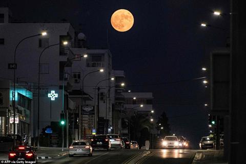 CYPRUS: The Blue Supermoon rises above vehicles along a street in Nicosia