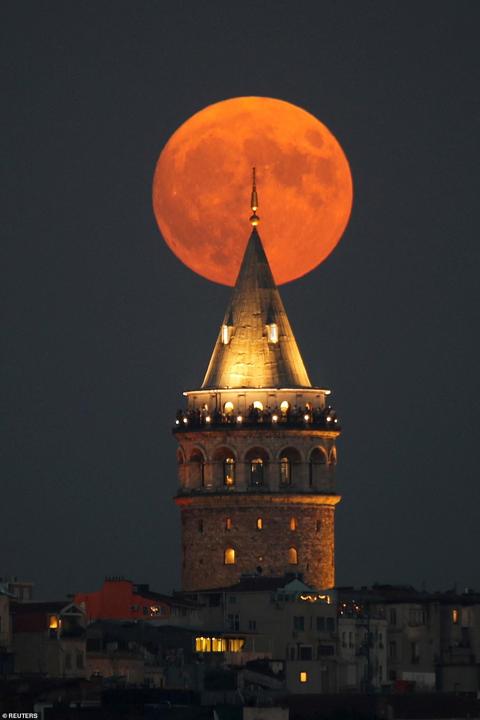 A full moon known as the Blue Moon rises behind the Galata Tower in Istanbul