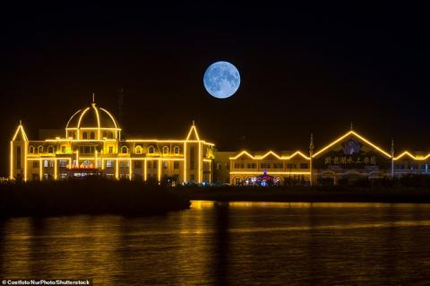 CHINA: A supermoon is seen above buildings at Wolong Lake Scenic area in Shenyang, Liaoning province, China