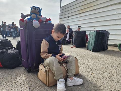طفل فلسطيني يلهو بينما الازدحام من حوله أمام معبر رفح البري بين قطاع غزة ومصر، حيث حركة السفر تشهد تعقيداً شديداً منذ اندلاع الحرب الإسرائيلية
