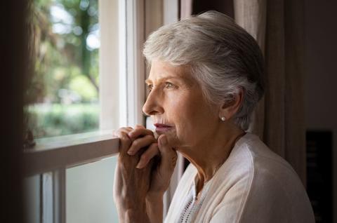 senior woman looking through window