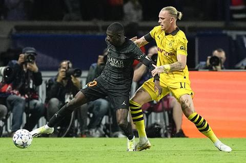 PSG s Ousmane Dembele, left, is challenged by Dortmund s Marius Wolf during the Champions League group F soccer match between Paris Saint-Germain and Borussia Dortmund, at the Parc des Princes stadium in Paris, France, Tuesday, Sept. 19, 2023. (AP Photo/Michel Euler)