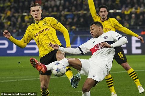 PSG s Kylian Mbappe, centre, and Dortmund s Nico Schlotterbeck, left, challenge for the ball during the Champions League Group F soccer match between Borussia Dortmund and Paris Saint-Germain at the Signal Iduna Park in Dortmund, Germany, Wednesday, Dec. 13, 2023. (AP Photo/Martin Meissner)