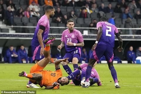 Netherlands Memphis Depay, down left, is challenged by Germany s players during the international friendly soccer match between Germany and Netherlands at the Deutsche Bank Park in Frankfurt, Germany on Tuesday, March 26, 2024. (AP Photo/Martin Meissner)
