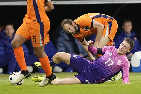 Netherlands Marten de Roon, back, challenges Germany s Florian Wirtz during the international friendly soccer match between Germany and Netherlands at the Deutsche Bank Park in Frankfurt, Germany on Tuesday, March 26, 2024. (AP Photo/Martin Meissner)