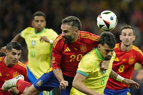 Spain s Dani Carvajal, centre, challenges for the ball with Brazil s Lucas Paqueta, centre right, during a friendly soccer match between Spain and Brazil at the Santiago Bernabeu stadium in Madrid, Spain, Tuesday, March 26, 2024. (AP Photo/Jose Breton)