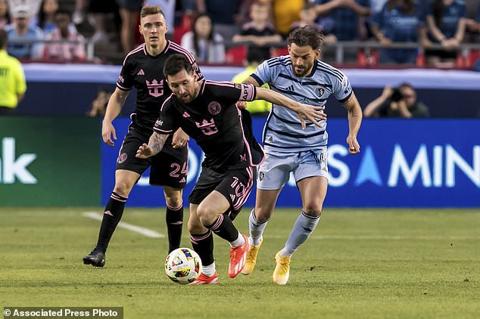 Inter Miami forward Lionel Messi (10) attempts to bypass Sporting Kansas City defender Tim Leibold, right, during the first half of an MLS soccer match Saturday, April 13, 2024, in Kansas City, Mo. (AP Photo/Nick Tre. Smith)