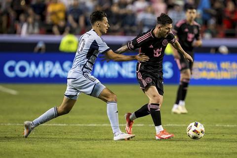 Inter Miami forward Lionel Messi, front right, shields off Sporting Kansas City forward Dániel Sallói, left, during the first half of an MLS soccer match on Saturday, April 13, 2024, in Kansas City, Mo. (AP Photo/Nick Tre. Smith)